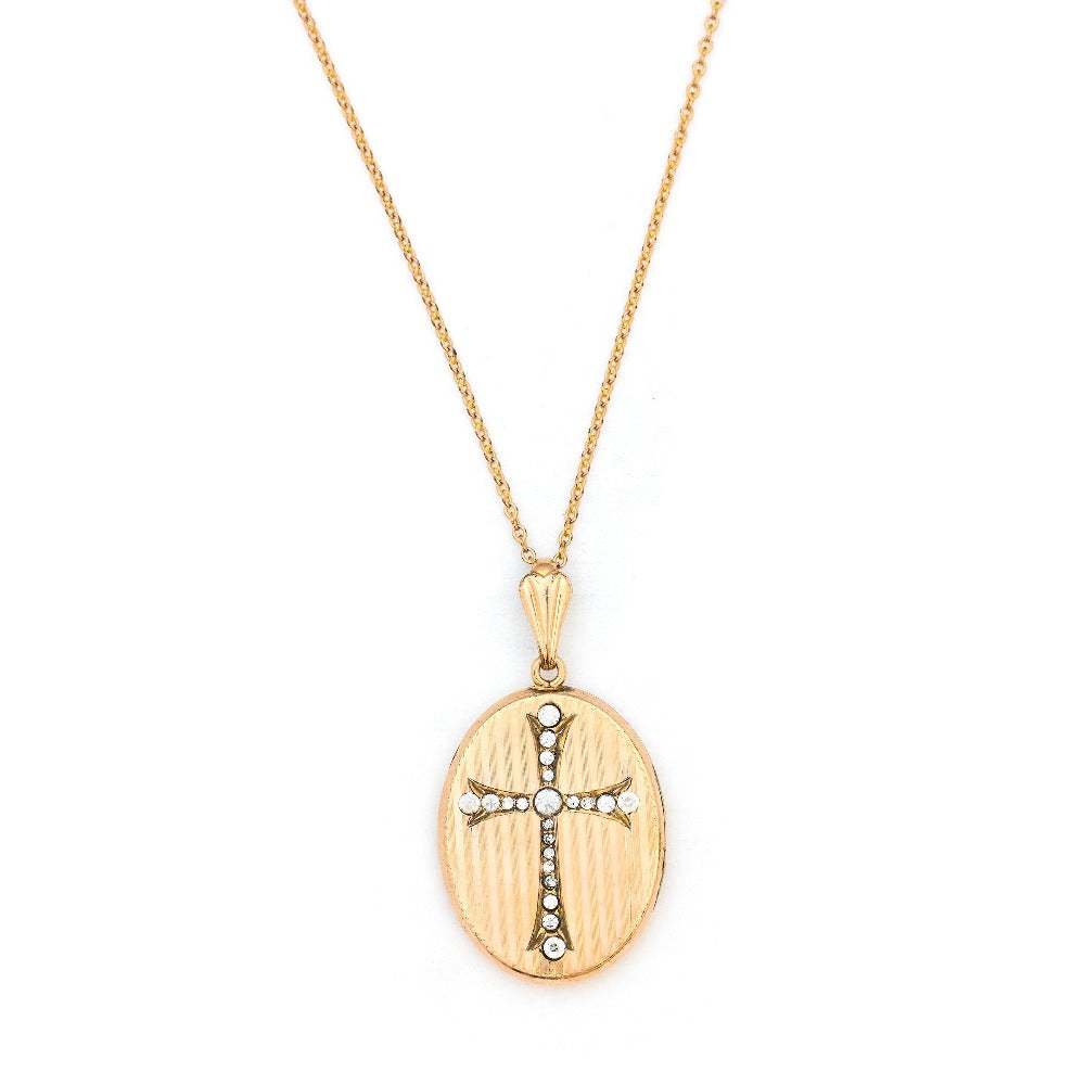 This oval locket features a white paste stone encrusted cross with a pinstripe backdrop. The letter EM are inscribed on the back. It opens to hold two photos, includes one original frame and pairs perfectly with one of our antique gold fill chains.  Front Locket view