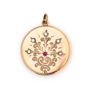 This round Victorian locket features a playful design which uses curlicues and flourishes to enhance the white and red paste stones. It opens to hold two photos, includes both original frames and pairs perfectly with one of our antique gold fill chains.  Front Locket view