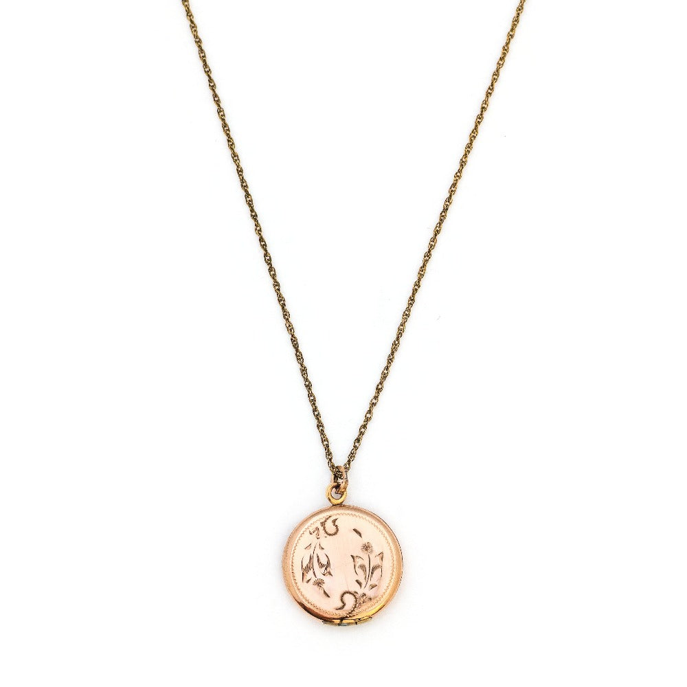 This petite round locket features a playful daisy pattern and a finely etched zigzag design around the border. It opens to hold two photos and pairs perfectly with one of our antique gold fill chains.  From Locket View