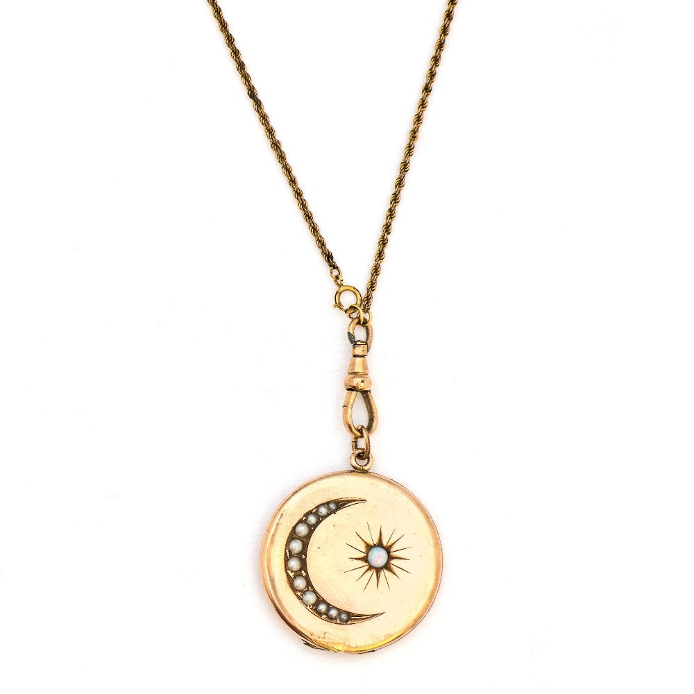 This large round locket features a pearl encrusted crescent moon and a starburst with a 4 mm opal at the center. It opens to hold two photos and pairs perfectly with one of our antique gold fill chains.  Front Locket View