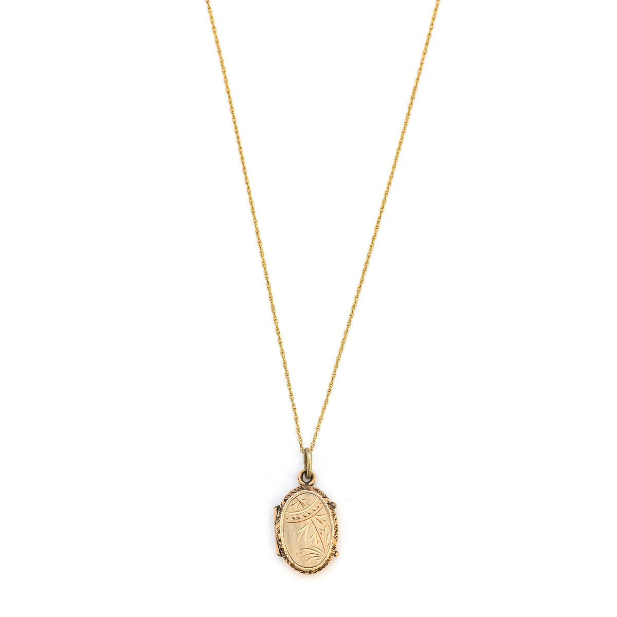 This petite oval 14K gold locket features a classic Victorian sparrow surrounded by carefully etched greenery on the front and back. It opens to hold two photos and pairs perfectly with one of our antique 14K gold chains. Front locket view, shown on chain