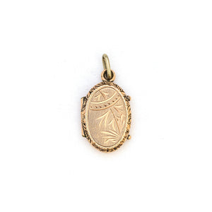 This petite oval 14K gold locket features a classic Victorian sparrow surrounded by carefully etched greenery on the front and back. It opens to hold two photos and pairs perfectly with one of our antique 14K gold chains. back locket view.