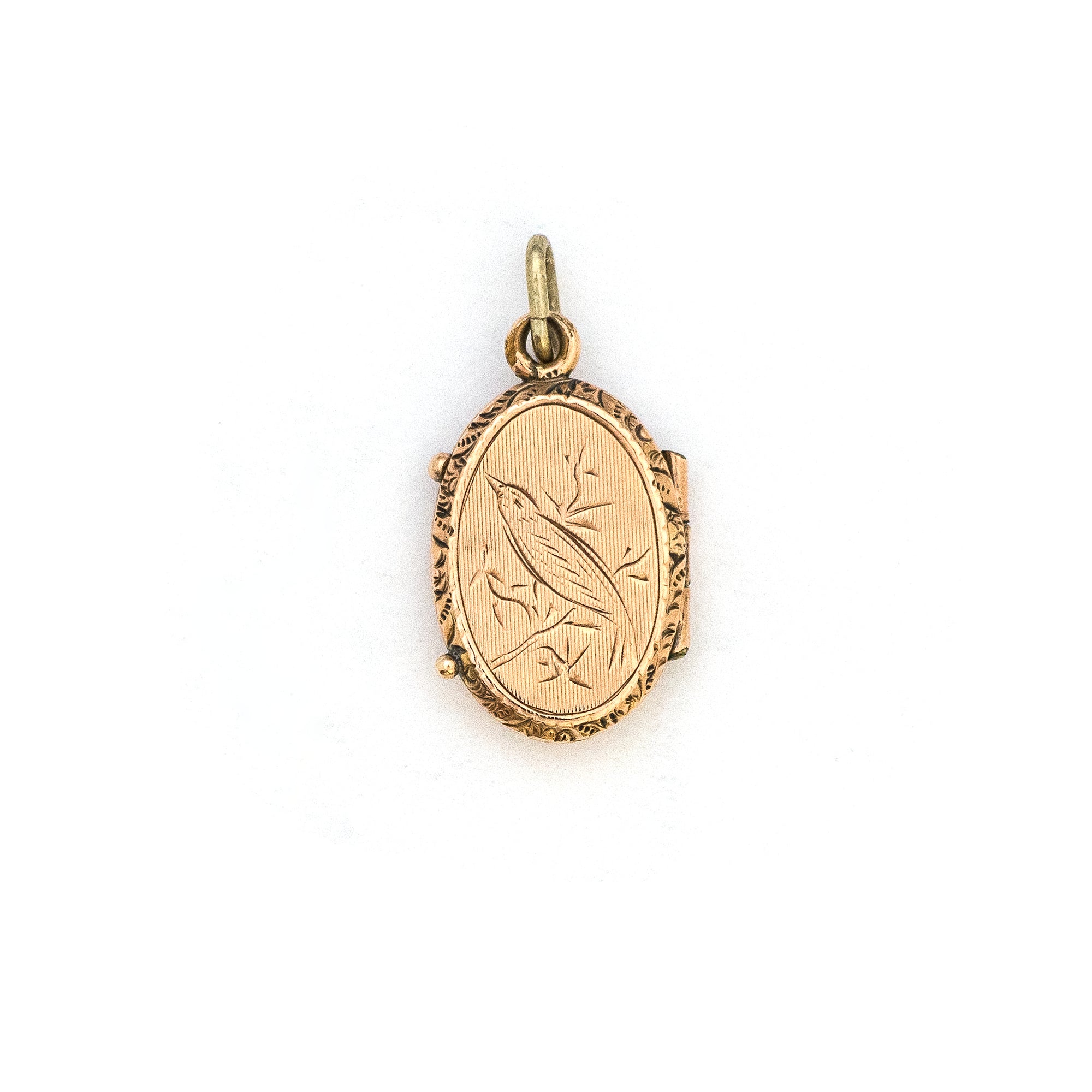 This petite oval 14K gold locket features a classic Victorian sparrow surrounded by carefully etched greenery on the front and back. It opens to hold two photos and pairs perfectly with one of our antique 14K gold chains. Front locket view