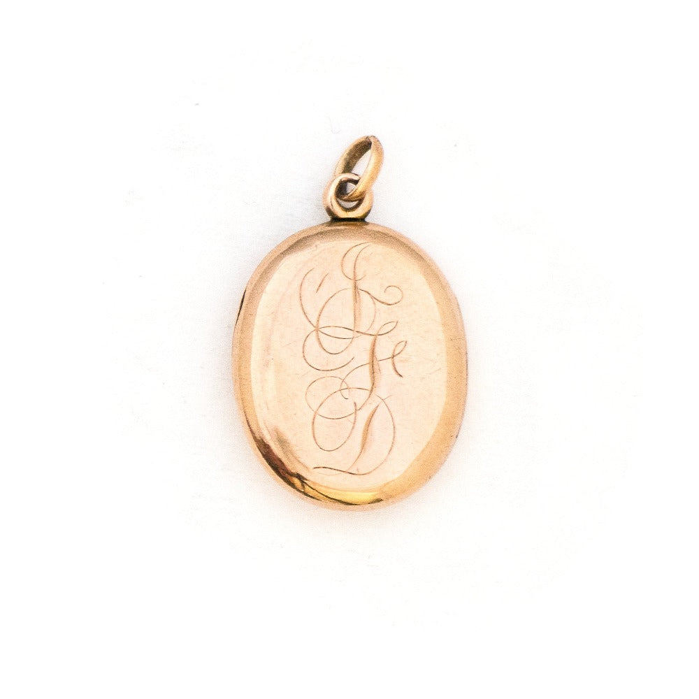 This classic oval 10K gold locket features a simple Victorian starburst with a genuine diamond at it's center and the letters JFD  inscribed on the back. It opens to hold two photos, includes one original frame and pairs perfectly with one of our antique 14K gold chains.  Back Locket View