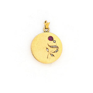 This petite 14K gold round locket features a whimsical floral design encrusted with 8 diamonds and a pear shaped ruby. It opens to hold two photos, includes one original frame and pairs perfectly with one of our antique 14K gold chains.  Front Locket View