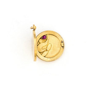 This petite 14K gold round locket features a whimsical floral design encrusted with 8 diamonds and a pear shaped ruby. It opens to hold two photos, includes one original frame and pairs perfectly with one of our antique 14K gold chains.  Open Locket View