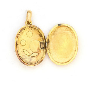 OpThis 18K gold oval locket features 10 pearls scatters throughout a delicate floral design complete with black enamel details. It opens to hold two photos pairs perfectly with one of our antique 14K gold chains. Open locket view