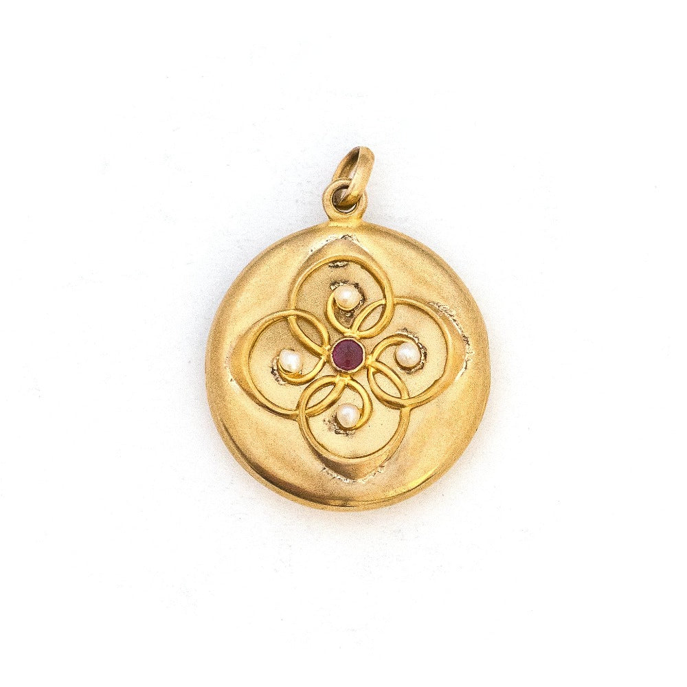 This 14K gold round locket features a raised circular design centered around a beautiful ruby and 4 pearls. The initials FES are intricately inscribed on the back. It opens to hold two photos, includes one original frame and pairs perfectly with one of our antique 14K gold chains.  Front Locket View