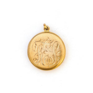 This 14K gold round locket features a raised circular design centered around a beautiful ruby and 4 pearls. The initials FES are intricately inscribed on the back. It opens to hold two photos, includes one original frame and pairs perfectly with one of our antique 14K gold chains.  Back locket view