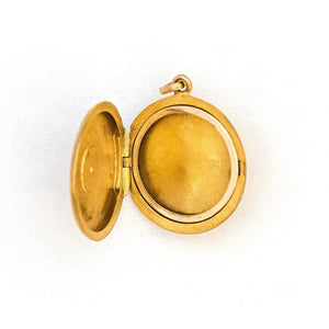 This 14K gold round locket features a raised circular design centered around a beautiful ruby and 4 pearls. The initials FES are intricately inscribed on the back. It opens to hold two photos, includes one original frame and pairs perfectly with one of our antique 14K gold chains.  Open locket view