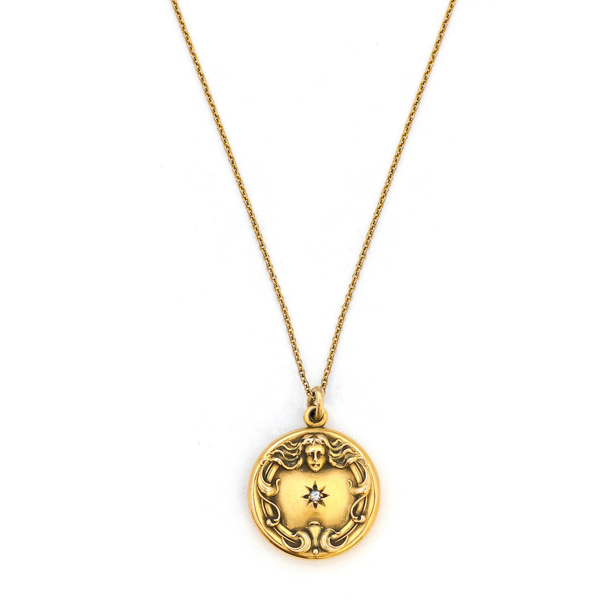 This breathtaking 14K gold locket features a woman in raised relief with her hair swirling around the lockets perimeter and a Victorian starburst with a 3 point diamond at its center. The initials MN are elegantly inscribed on the back. It opens to hold two photos, includes both original frames and pairs perfectly with one of our antique 14K gold chains. Front Locket view