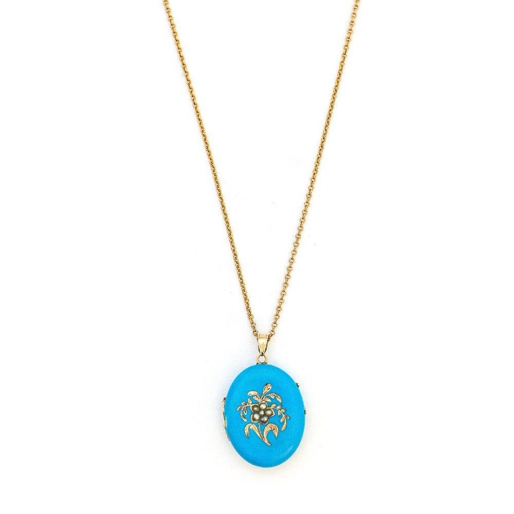 This 14K gold oval locket features pearls at the center of an intricate forget-me-not flower with a rich robin egg blue enamel background. It opens to hold two photos, includes one original frame and pairs perfectly with one of our antique 14K gold chains. Front Locket View