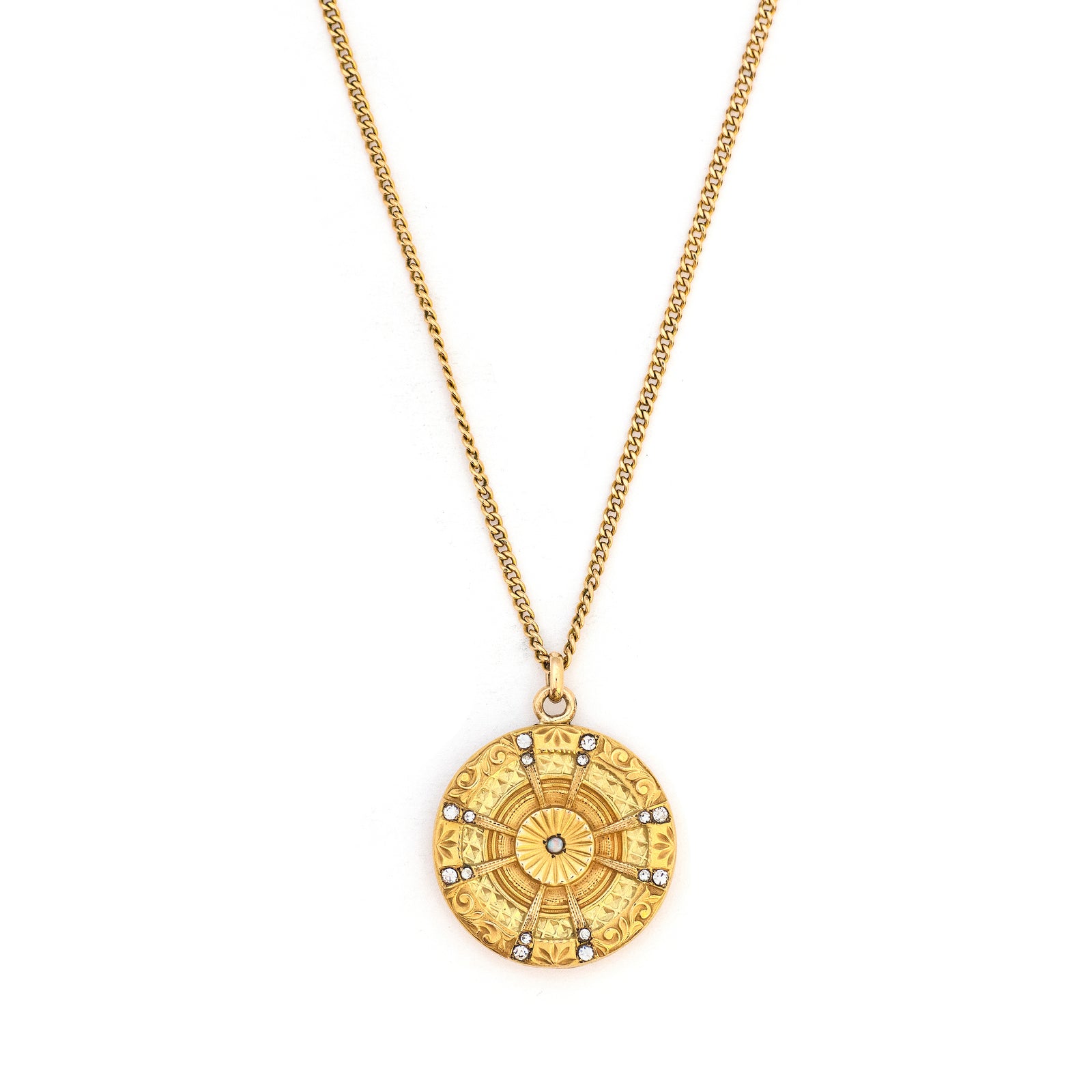 This striking round locket features an opal at it's center with intricate multi layered details and white paste stones radiating out in a sun-like pattern. It opens to hold two photos and pairs perfectly with one of our antique gold fill chains, front locket view