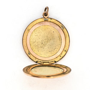 This round locket features a delicately etched wreath of forget-me-not flowers with purple paste stones throughout the design as the flower centers. The initials EM are inscribed on the back. It opens to hold two photos, includes both original frames and pairs perfectly with one of our antique gold fill chains.  Open locket view