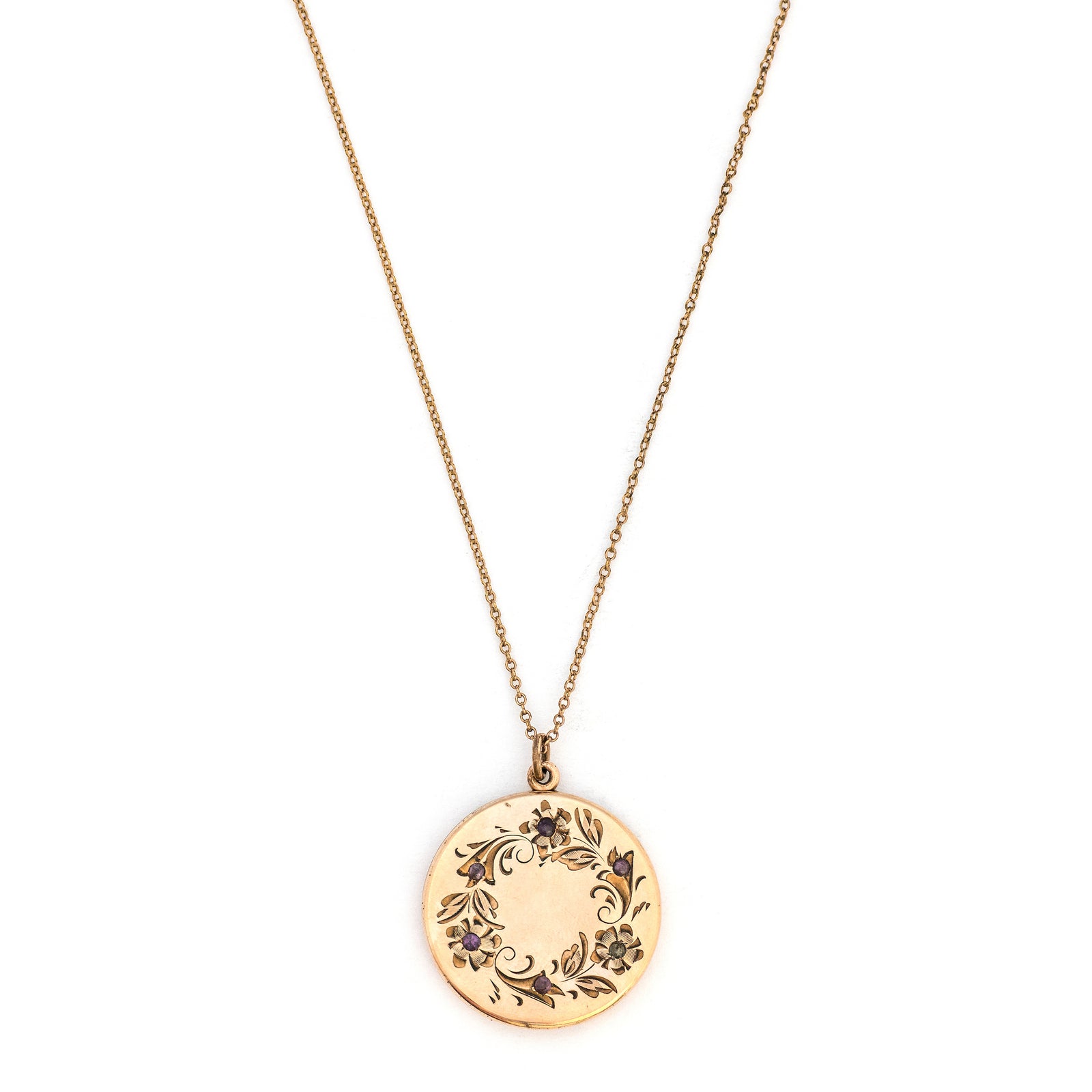 This round locket features a delicately etched wreath of forget-me-not flowers with purple paste stones throughout the design as the flower centers. The initials EM are inscribed on the back. It opens to hold two photos, includes both original frames and pairs perfectly with one of our antique gold fill chains.  Front Locket View