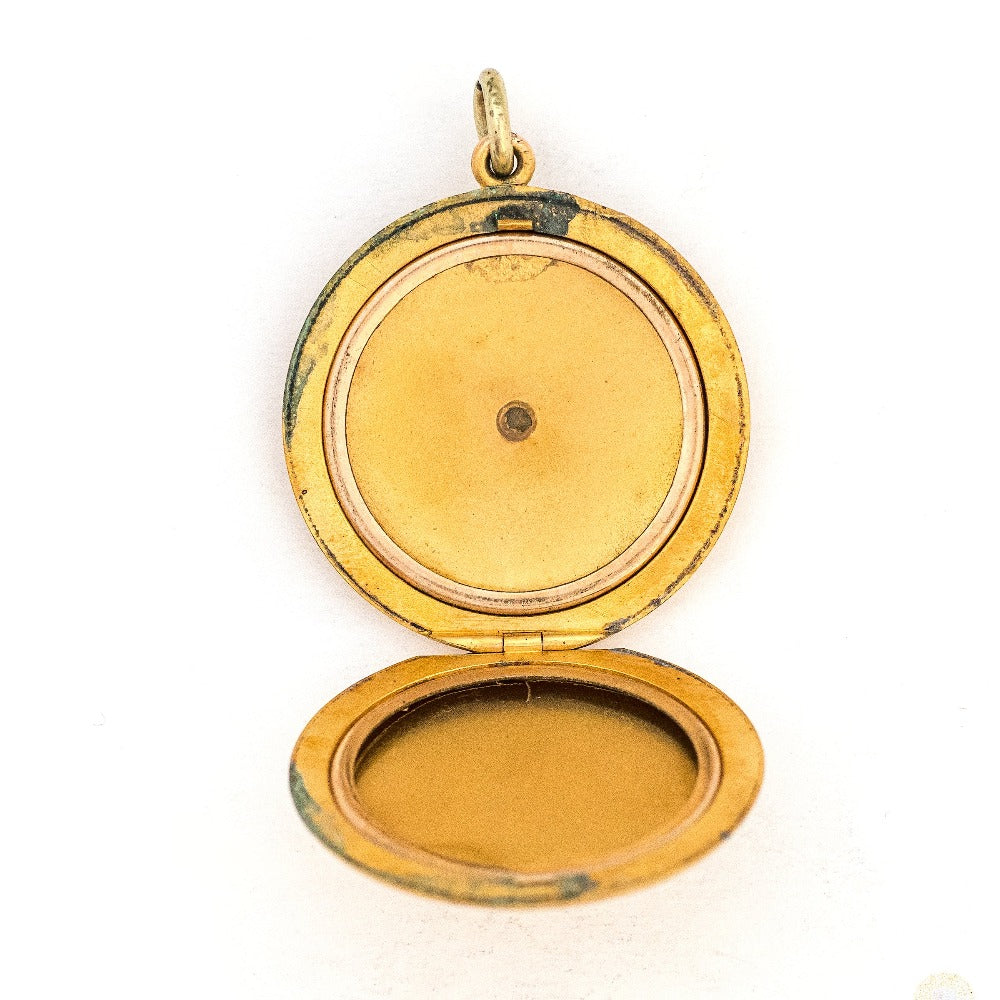 This large round locket features a classic Victorian starburst with a 3.5 mm white paste stone at the center. It opens to hold two photos, includes both original frames and pairs perfectly with one of our antique gold fill chains. Open locket view