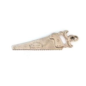This unique saw charm is made of sterling silver and features intricate realistic details and the E.C. ATKINS & Co. Maker Mark, a prominent saw manufacturer out of Cleveland, OH, established in 1855. Paired with one of our antique silver chains, this saw charm can be worn both as a pendant or in a cluster of charms. Front charm view