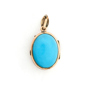 This absolutely gorgeous robin egg blue enamel and gold fill locket is oval shaped and features a sparrow carrying a scroll in it's beak. The sparrow is surrounded by an intricate golden wreath. It opens to hold two photos, includes both original frames and glass, and pairs perfectly with one of our antique gold fill chains.  Back locket view