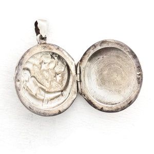 This round sterling silver Victorian locket features a woman lying in a crescent moon surrounded by stars. It opens to hold two photos and pairs perfectly with one of our antique sterling silver chains.  Open locket view