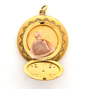 This incredibly unique gold fill locket features red and white paste stones surrounding a central starburst. This locket has two compartments: one that holds a photo, original frame included, and a second secret compartment that holds a tiny sachet. The inscribed text inside the locket tells us this design was patent pending (See photos).  We've never seen anything like it! This gem pairs perfectly with one of our antique gold fill chains.  Open locket, showing sachet