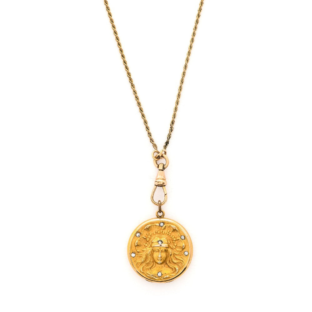 This breathtaking Art Nouveau locket features a woman with flowing hair set in front of a pansy. There are white paste stones scattered throughout the beautiful design. It opens to hold two photos and pairs perfectly with one of our antique gold fill watch chains.  Front Locket View, shown on chain