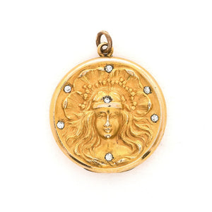 This breathtaking Art Nouveau locket features a woman with flowing hair set in front of a pansy. There are white paste stones scattered throughout the beautiful design. It opens to hold two photos and pairs perfectly with one of our antique gold fill watch chains.  Front view