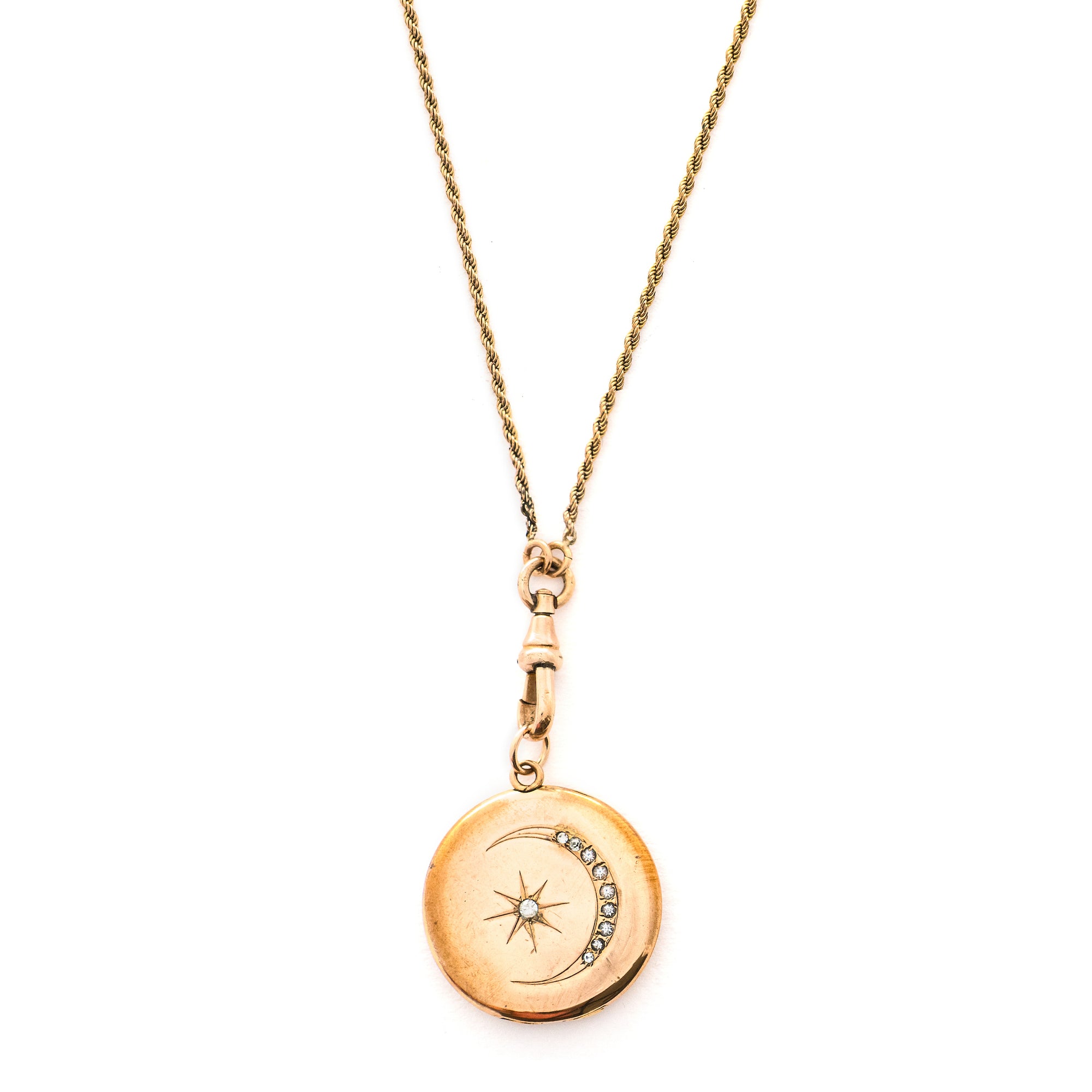 This classic Victorian locket features a large crescent moon surrounding a bright starburst with 10 white Victorian paste stones throughout the design. It opens to hold two photos, includes one original frame and pairs perfectly with one of our antique gold fill chains.  Front locket view