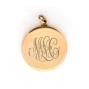 This round, matte locket features an ornate "S" in Victorian era script on the front and the initials MLC on the back. It opens to hold two photos, includes both original frames and pairs perfectly with one of our antique gold fill chains.  Back locket view