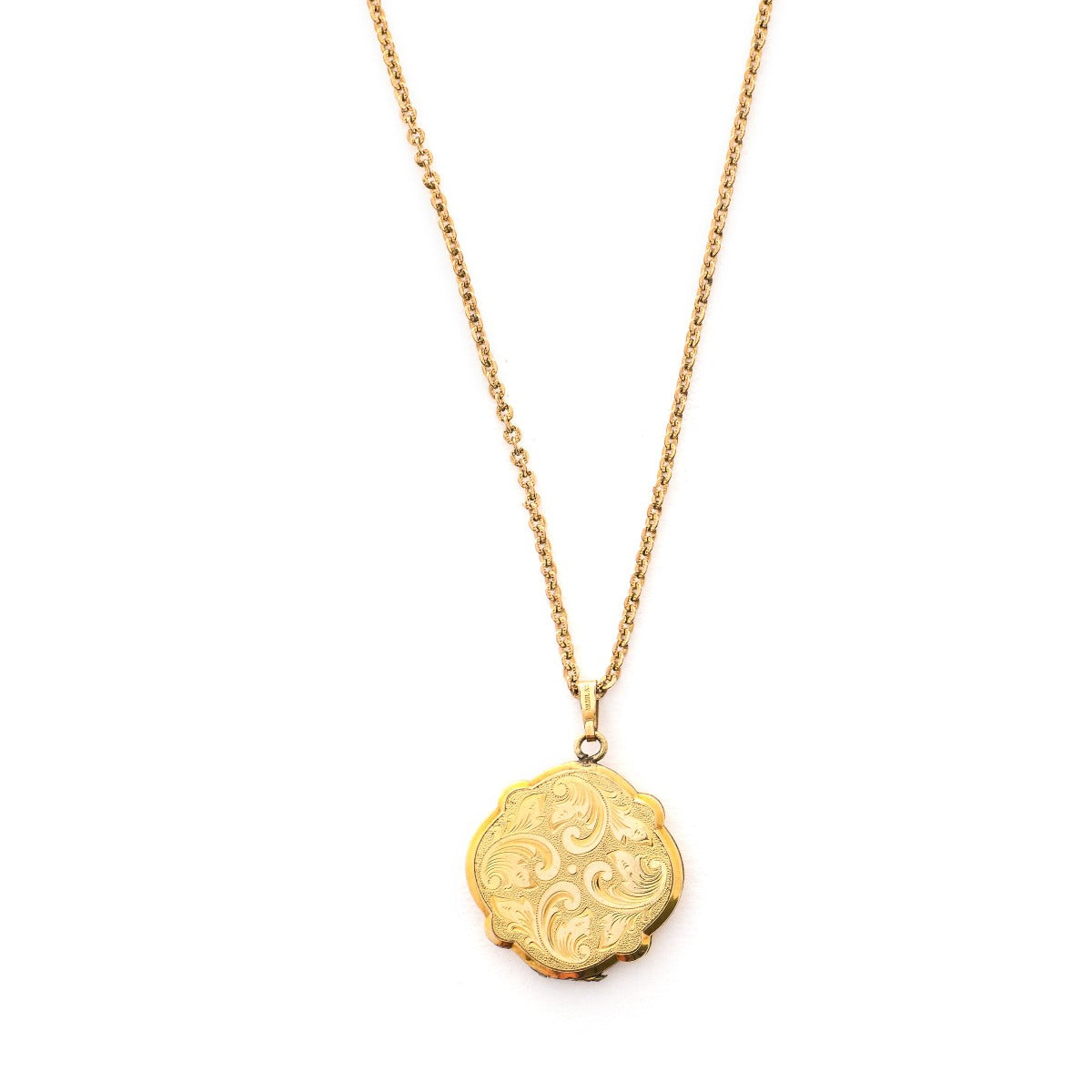 This uniquely shaped circular locket features a delicately etched curlicue design on front and back. It opens to hold two photos, includes one original frame and pairs perfectly with one of our antique gold fill chains. Locket front view