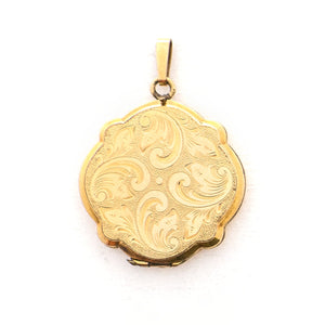 This uniquely shaped circular locket features a delicately etched curlicue design on front and back. It opens to hold two photos, includes one original frame and pairs perfectly with one of our antique gold fill chains. Locket front view