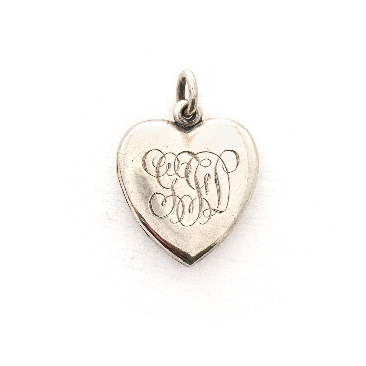 This heart shaped sterling silver locket features a simple and delicately etched tulip. The initials GFD  are inscribed on the back. It opens to hold two photos, includes both original frames and pairs perfectly with one of our vintage sterling silver chains. Back locket view