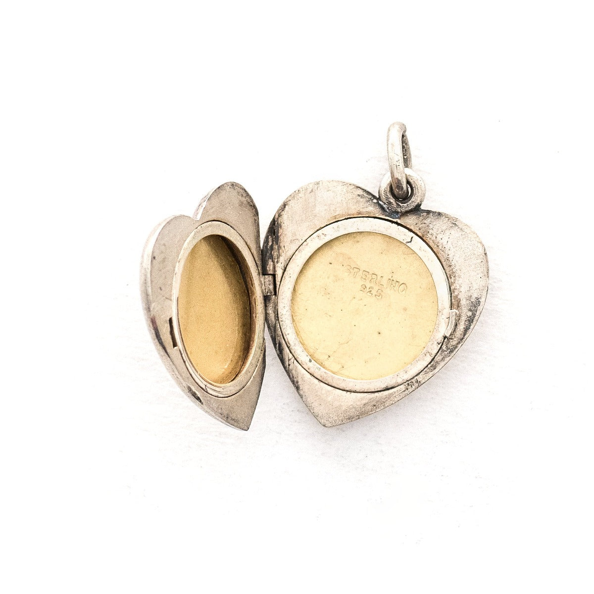 This heart shaped sterling silver locket features a simple and delicately etched tulip. The initials GFD  are inscribed on the back. It opens to hold two photos, includes both original frames and pairs perfectly with one of our vintage sterling silver chains. Open locket view