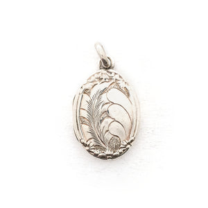 This oval sterling silver locket features two beautiful plumes with tiny flowers at it's base. It opens to hold two photos and pairs perfectly with one of our vintage sterling silver chains. Front locket view