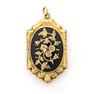 This ornate oval locket features beautiful black enamel with three forget-me-not flowers at the center of swirling vines. It opens to hold two photos, includes both original frames and pairs perfectly with one of our antique gold fill chains. Front Locket View