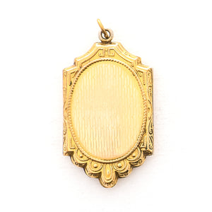 This ornate oval locket features beautiful black enamel with three forget-me-not flowers at the center of swirling vines. It opens to hold two photos, includes both original frames and pairs perfectly with one of our antique gold fill chains. Back locket view