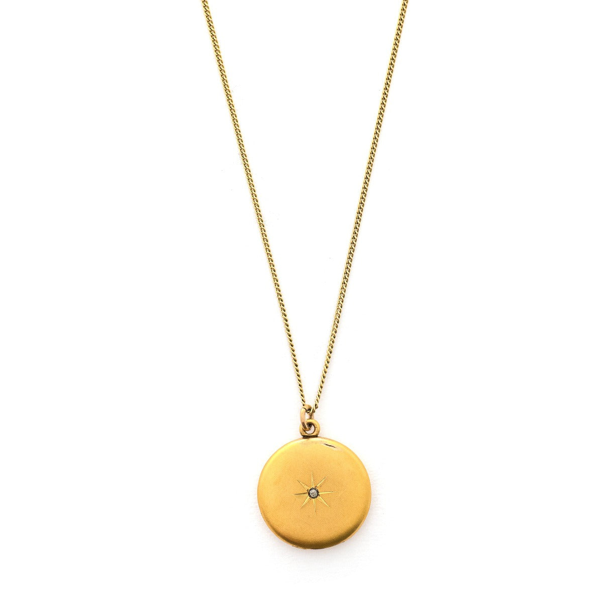 This classic round locket features a simple Victorian starburst with a white paste stone at it's center. It opens to hold two photos, includes one original frame and pairs perfectly with one of our antique gold fill chains. Front locket view, shown on chain