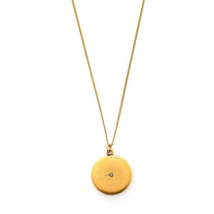 This classic round locket features a simple Victorian starburst with a white paste stone at it's center. It opens to hold two photos, includes one original frame and pairs perfectly with one of our antique gold fill chains. Front locket view, shown on chain