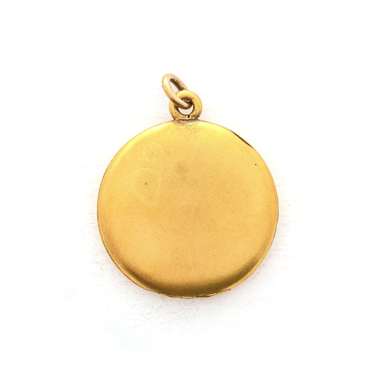 This classic round locket features a simple Victorian starburst with a white paste stone at it's center. It opens to hold two photos, includes one original frame and pairs perfectly with one of our antique gold fill chains. Back locket view