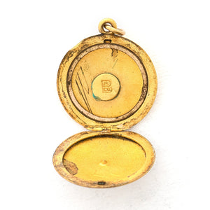 This classic round locket features a simple Victorian starburst with a white paste stone at it's center. It opens to hold two photos, includes one original frame and pairs perfectly with one of our antique gold fill chains. Open locket view