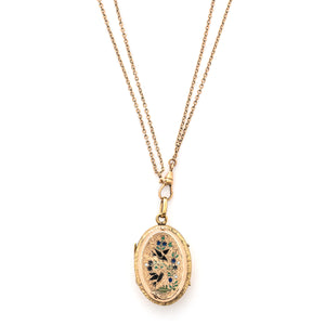 This striking oval locket features classic Victorian era symbolism with a pair of swallows surrounded by forget-me-not flowers enhanced with blue, white and green enamel throughout the design. It opens to hold two photos and pairs perfectly with one of our antique gold fill chains.  Front Locket view, shown on chain