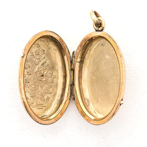 This striking oval locket features classic Victorian era symbolism with a pair of swallows surrounded by forget-me-not flowers enhanced with blue, white and green enamel throughout the design. It opens to hold two photos and pairs perfectly with one of our antique gold fill chains.  Open Locket view