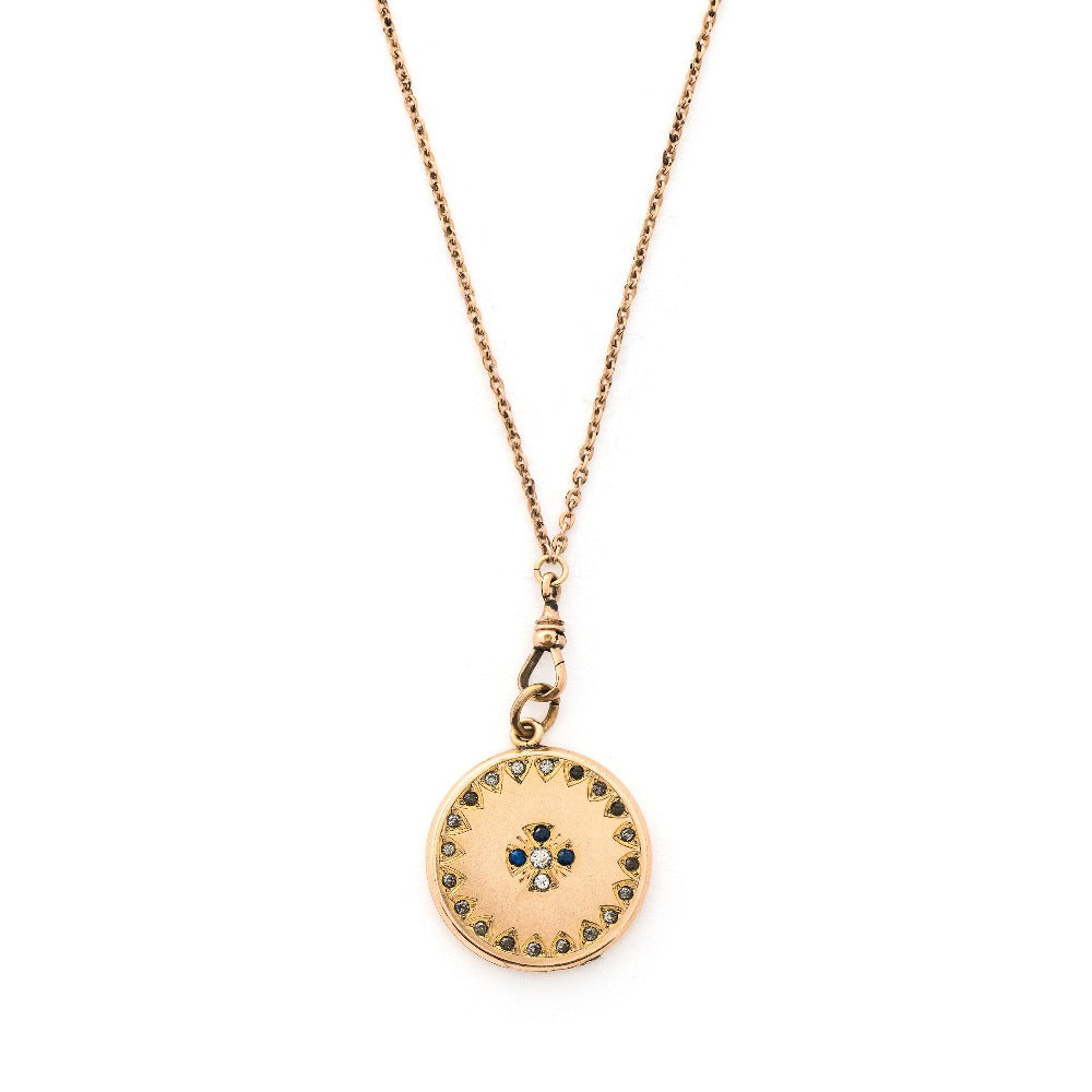 This round locket features a Maltese Cross, a symbol of protection, made up of blue, white and grey paste stones surrounded by a paste stone border. It opens to hold one photo and pairs perfectly with one of our antique gold fill chains.  Front locket view