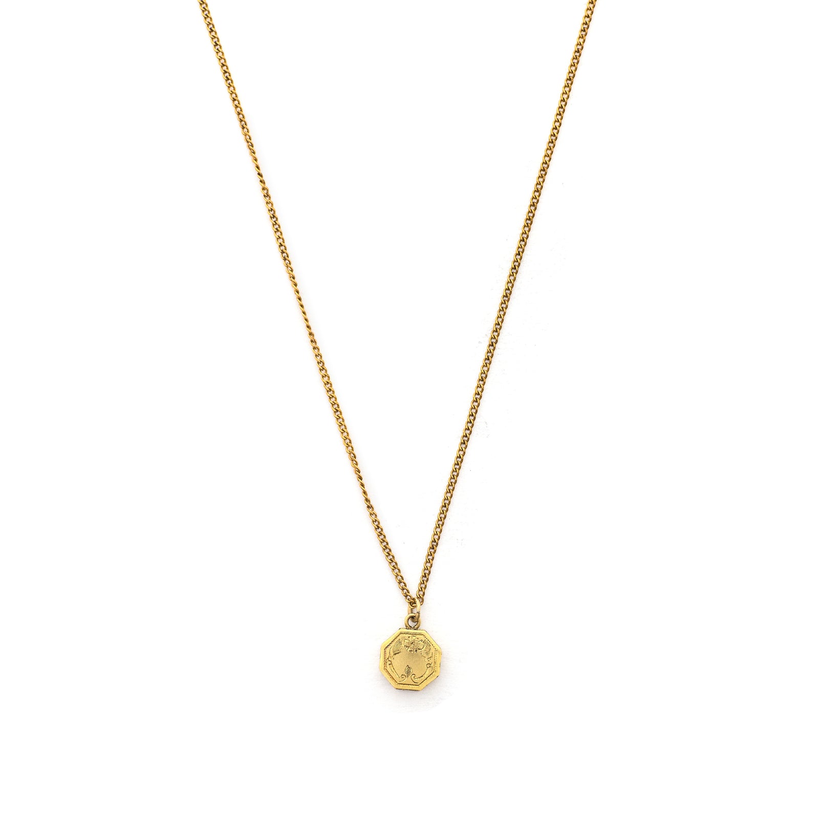 This petite octagonal locket features a delicately etched floral motif including a classic Victorian era symbol, the forget-me-not flower at the top of the design. It opens to hold two (very tiny!) photos and pairs perfectly with one of our antique gold fill chains.  Front locket view
