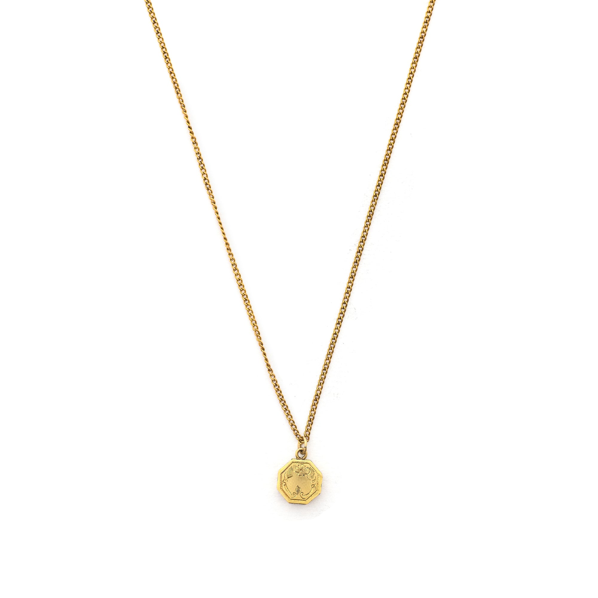 This petite octagonal locket features a delicately etched floral motif including a classic Victorian era symbol, the forget-me-not flower at the top of the design. It opens to hold two (very tiny!) photos and pairs perfectly with one of our antique gold fill chains.  Front locket view