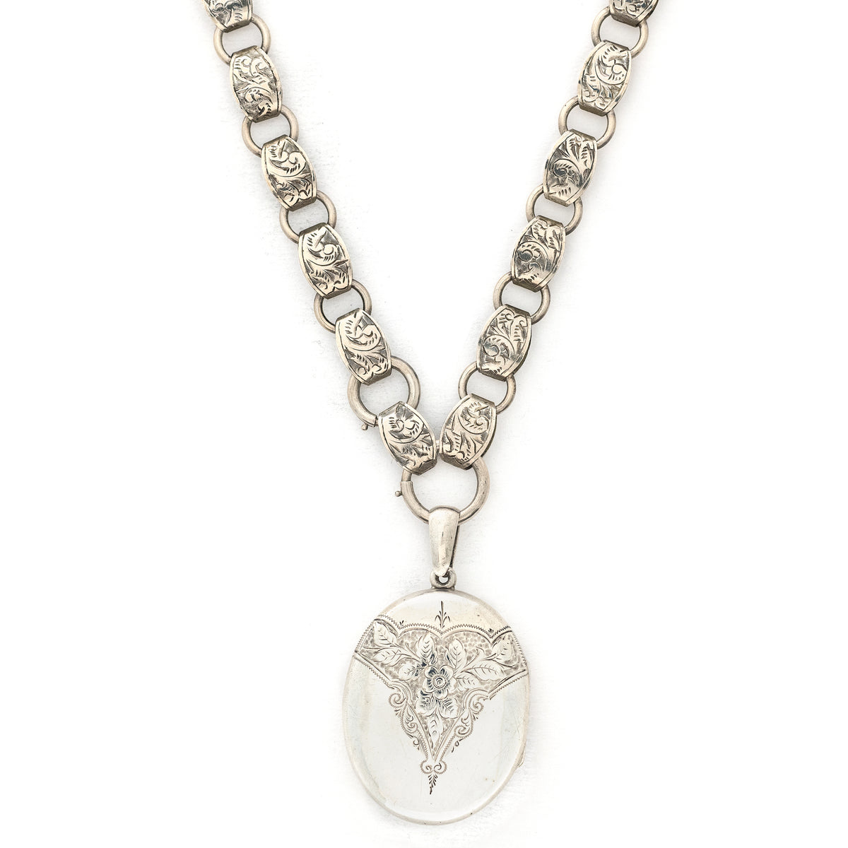 This large sterling silver oval locket features the classic Victorian symbol, a forget-me-not flower surrounded by greenery in a dramatic deep V shape and opens to hold two photos. We have paired this locket with an exquisite engraved Victorian sterling silver book chain from the same era. Front locket view on chain