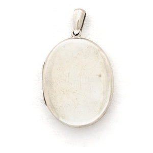 This large sterling silver oval locket features the classic Victorian symbol, a forget-me-not flower surrounded by greenery in a dramatic deep V shape and opens to hold two photos. We have paired this locket with an exquisite engraved Victorian sterling silver book chain from the same era. Back locket view