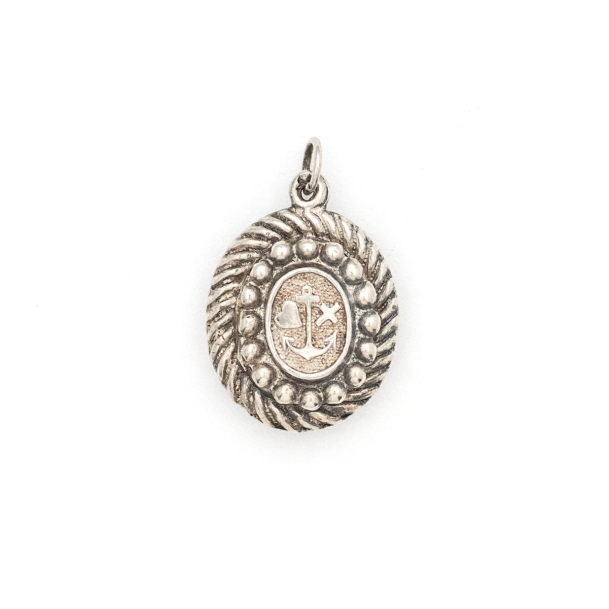 This oval sterling silver locket features an anchor, heart and cross at its center with surrounding filigree and rope patterns. The back of the locket is the same as the front. It opens to hold one photo and pairs perfectly with one of our antique sterling silver chains. Front locket view