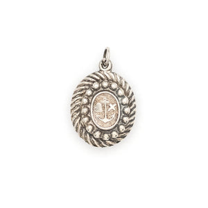 This oval sterling silver locket features an anchor, heart and cross at its center with surrounding filigree and rope patterns. The back of the locket is the same as the front. It opens to hold one photo and pairs perfectly with one of our antique sterling silver chains. Front locket view