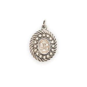 This oval sterling silver locket features an anchor, heart and cross at its center with surrounding filigree and rope patterns. The back of the locket is the same as the front. It opens to hold one photo and pairs perfectly with one of our antique sterling silver chains. Back Locket view