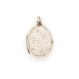 This oval sterling silver vintage locket features banded dark green malachite at its center with a beautifully etched leafed design on the back . It opens to hold two photos and pairs perfectly with one of our antique sterling silver chains. Back locket view